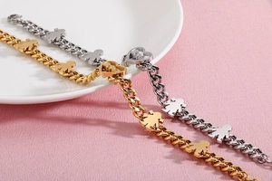 Detail of gold and silver heart bracelets with boy and girl charms and LOVE engraving