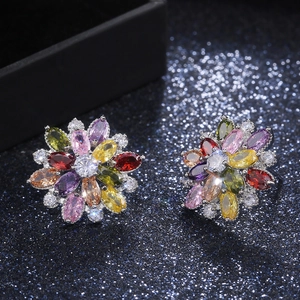 Detailed view of colorful sunflower earrings with marquise-cut gems on sparkling background