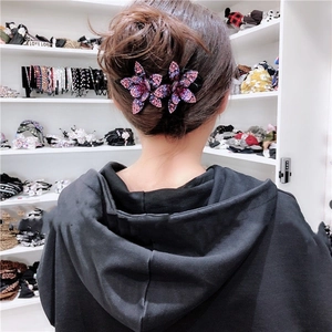 Close-up of elegant rhinestone flower hair clip worn on a woman's hair showing purple crystals
