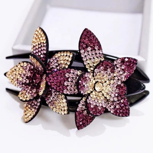 Detail of elegant large rhinestone flower hair clip with purple and pink crystals