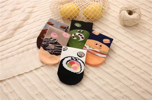 Flat lay of cotton crew socks with burger, sushi and donut food patterns on beige knit
