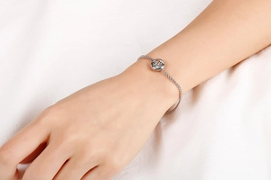 Detailed close-up of a silver zodiac titanium steel bracelet with diamond on wrist