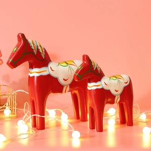 Traditional red Dala wooden horse figurines with floral patterns and LED string lights