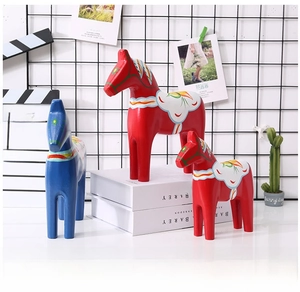 Three colorful wooden Dala Horse figurines with traditional Swedish folk art patterns