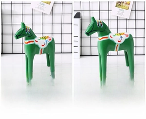 Comparison of small and large green Dala horse statues with traditional floral painting