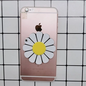 Supporto per telefono a forma di margherita bianca e gialla su un telefono oro rosa