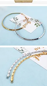 Detail of gold and silver choker necklaces featuring engraved cross patterns on segments