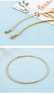 Nahaufnahme der goldenen Schlangenkette mit Karabinerverschluss und glattem Finish