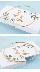 Detail einer goldenen Schlangenkette mit Karabinerverschluss auf Geschenkkarte