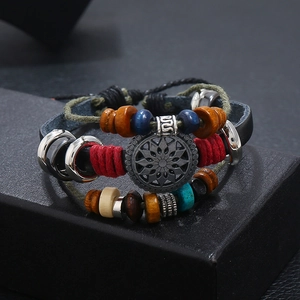 Detail of vintage bohemian leather bracelet with wooden beads and silver floral pendant