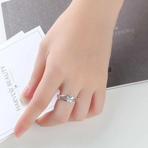 Elegante anillo de mariposa plateado con banda retorcida usado en una mano femenina