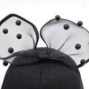Detail of black mesh bow and faux pearls on children's breathable princess sun hat