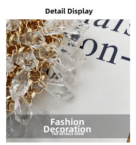 Macro detail of handmade clear crystal water drop beads on a gold metal woven evening bag
