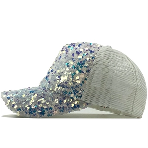 Detail of white mesh baseball cap featuring shimmering iridescent sequins and breathable fabric