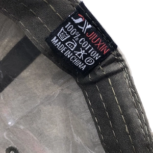 Gros plan détaillé de l'étiquette d'entretien 100% coton dans une casquette camouflage