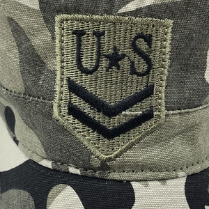 Macro shot of embroidered shield patch with U.S. stars and stripes on camouflage cadet cap