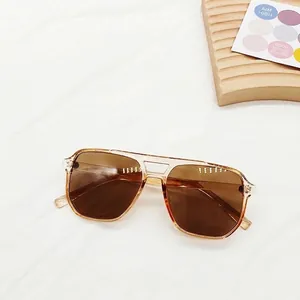 Close-up of square sunglasses with champagne resin frame and dark brown lenses