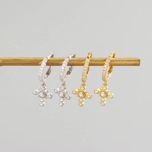 Detail van gouden en zilveren S925 sterling zilveren kruis oorbellen met fonkelende stenen