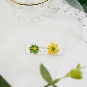 Macro shot of 925 silver post daisy earrings in yellow and green floral design