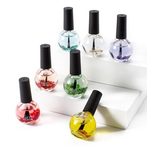 Detailed view of spherical 15ml nail oil bottles with colorful liquids and dried flowers