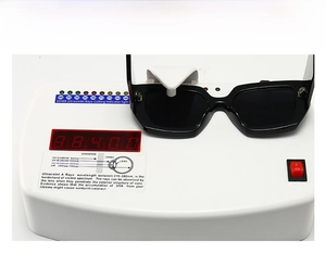 Black square sunglasses undergoing UV400 protection testing on a professional device