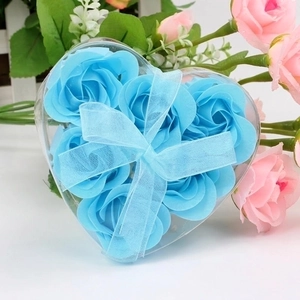 Macro shot of 6 blue rose soap flowers in a heart-shaped clear gift box with a bow