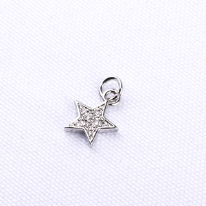 Macro shot of silver star pendant with micro-paved zircons and polished finish