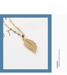 Macro view of feather pendant necklace with 18K gold plating and cubic zirconia