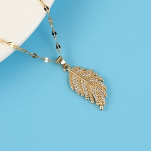 Elegant 18K gold plated titanium necklace with zircon-encrusted feather pendant on blue background