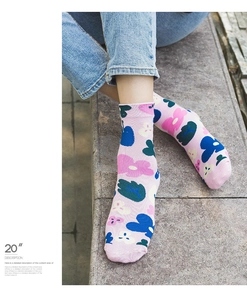 Close-up of pink floral crew socks with vibrant flower patterns worn with blue jeans