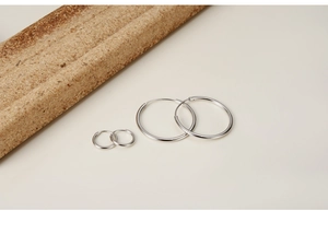 Polished S925 sterling silver hoop earrings in two sizes on a minimalist background