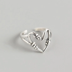 Detail view of vintage silver heart knot ring showing twisted texture and retro finish