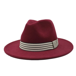 Close-up of wine red wool fedora hat with a striped grosgrain ribbon trim and wide flat brim