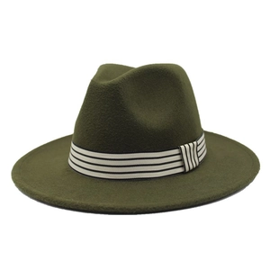 Macro detail of dark green wool fedora hat featuring classic black and white striped band