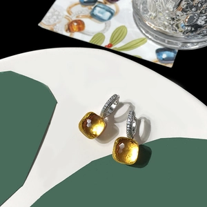 Detailed close-up of amber yellow square faceted crystal earrings with silver micro-pave