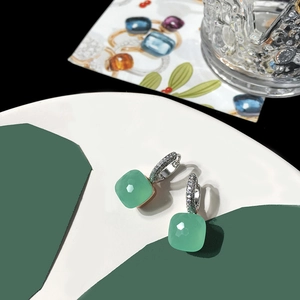 Close-up of S925 silver earrings featuring faceted green crystals and pavé cubic zirconia