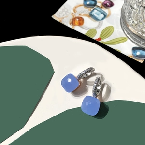 Macro view of blue square-cut gemstone earrings with micro-pave zirconia silver settings