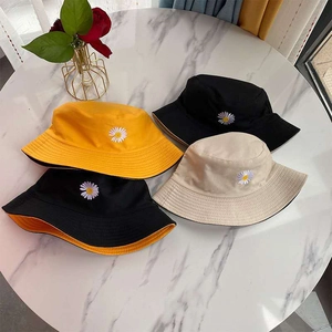 Daisy embroidered double-sided bucket hats in yellow, black, and beige colors