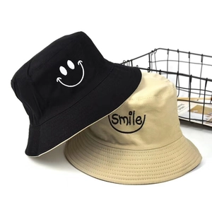 Detail of cotton daisy bucket hats in black and beige with smile embroidery