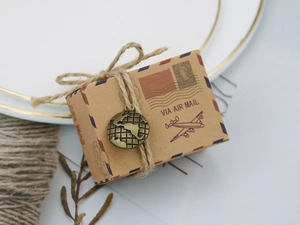 Detail of vintage kraft paper candy box with air mail print, twine and globe charm
