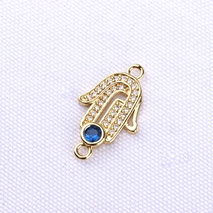 Gold Hamsa Hand connector pendant with blue evil eye and sparkling white crystals