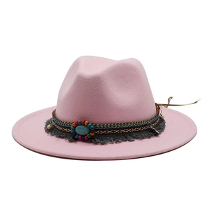 Detail of pink wool fedora with ethnic woven band, turquoise stone, and grey tassels