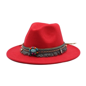 Detail of red wool fedora with ethnic beaded band, turquoise stone, and fringe tassels