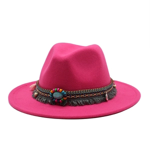 Detail of rose red wool fedora featuring bohemian woven band and turquoise stone