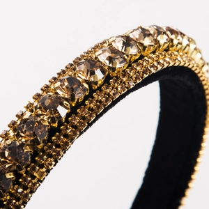 Close-up of luxury baroque headband with amber and gold rhinestones on black base