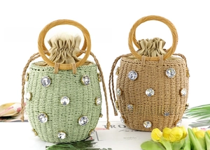 Detail of straw bucket bags with rhinestones, wooden ring handles and drawstring lining