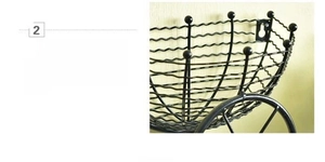 Detail of matte black wrought iron bicycle wall basket with wave-pattern hollow weaving