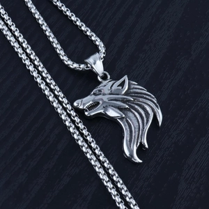 Macro shot of a highly detailed silver wolf head pendant on a sturdy stainless steel chain