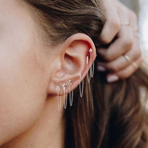 Macro shot of S925 silver earring set with tassel chains and star motifs on ear