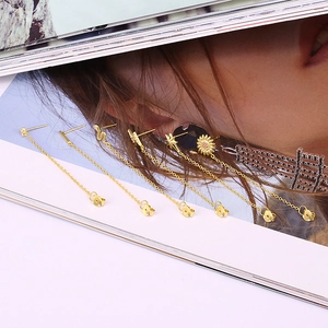 Detailed macro view of S925 sterling silver tassel earrings with sunflower and star motifs